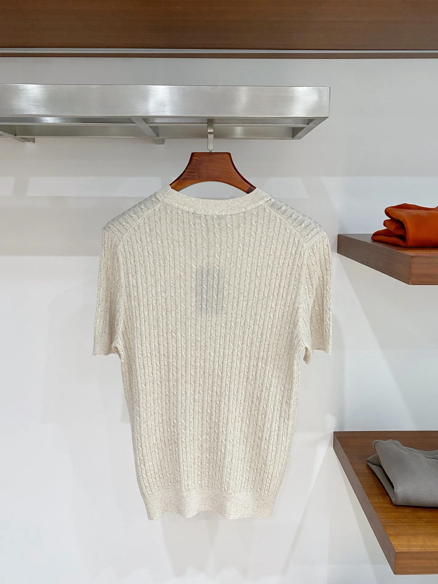 Loro Piana Vertical Twist Twist Round Neck Knitted Short Sleeve Fabric: High-count fine knitted yarns are selected, and the Classic three-dimensional cable knitting process is used to create a vertical twist texture. After multiple rounds of softening pre-treatment, the rough and itchy feeling of ordinary cable fabrics is eliminated, and it is soft and skin-friendly; The micro gaps formed by the knitting enhance the air circulation effect, and the spring and summer Breathable effect is outstanding, perspiration is not easy to stick to the back; The fabric texture has a natural matte texture, which is not easy to show signs of wear and shine. It has excellent toughness and is not prone to pilling and snagging for daily wear. It is a high-end old-money style knitted fabric with a rich sense of detail. Style and details: Optimized right-shoulder round-neck style, with dense ribbing at the neckline, excellent shaping effect, long-term wear and repeated washing, it is not easy to collapse the collar or become loose; short-sleeve cuffs are narrow ribbing, neatly cut, and the cuffs will not shift randomly when raising hands in daily life; the body adopts a moderate straight style, the vertical twist pattern visually elongates the body shape, cleverly modifies the waist and upper body contours, and is more tolerant to fatter figures; The ribbing at the hem is flat and gathered, and the wiring is precisely hidden. The entire piece abandons the conspicuous external logo and relies on the cable texture to present texture. The details are low-key and elegant, and it is suitable for various daily matching ideas. Color selection: Three low-saturated colors: soft oatmeal, light fog gray, and dark charcoal gray, suitable for commuting to work, holiday travel, and daily leisure travel. Style positioning: Italian Retro is for light business, elegant daily casual, and light luxury vacation wear. The shape is very inclusive and can be worn by both men and women. It has a high-end texture when worn alone. It can also reveal exquisite texture details when layered with a suit jacket, making it easy to create a textured outfit. Sizes:M-3XL